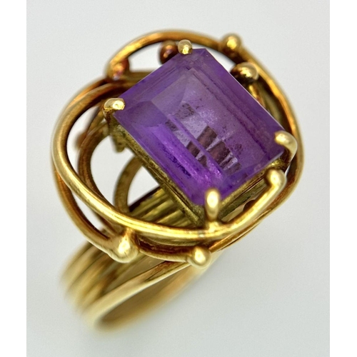 225 - A Vintage 18k Yellow Gold Amethyst Ring. A central 3ct emerald cut amethyst amongst an abstract swir... 