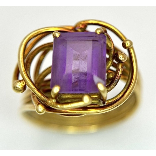 225 - A Vintage 18k Yellow Gold Amethyst Ring. A central 3ct emerald cut amethyst amongst an abstract swir... 