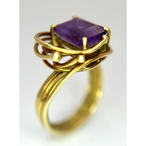 225 - A Vintage 18k Yellow Gold Amethyst Ring. A central 3ct emerald cut amethyst amongst an abstract swir... 