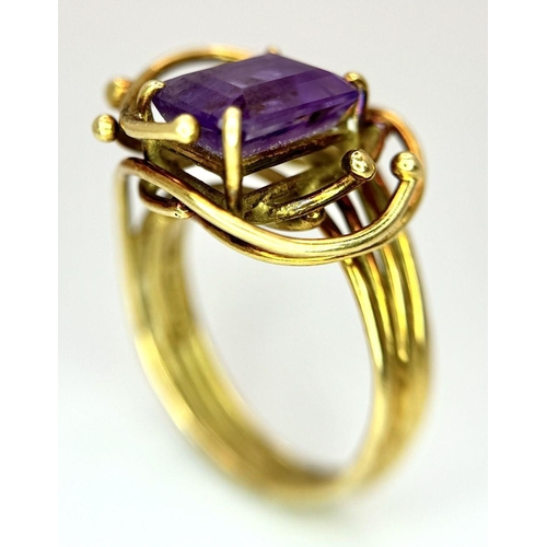 225 - A Vintage 18k Yellow Gold Amethyst Ring. A central 3ct emerald cut amethyst amongst an abstract swir... 