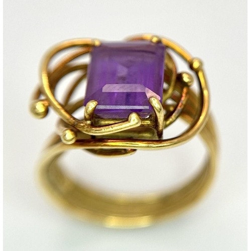 225 - A Vintage 18k Yellow Gold Amethyst Ring. A central 3ct emerald cut amethyst amongst an abstract swir... 