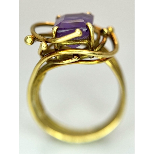 225 - A Vintage 18k Yellow Gold Amethyst Ring. A central 3ct emerald cut amethyst amongst an abstract swir... 