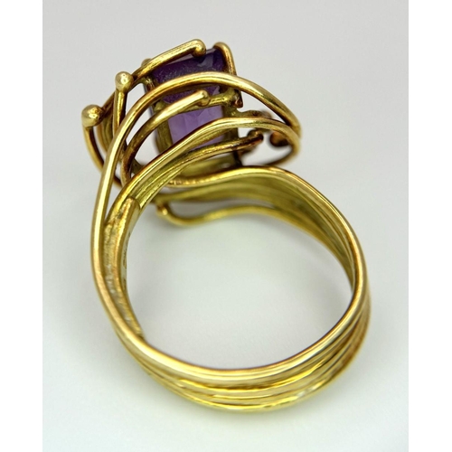 225 - A Vintage 18k Yellow Gold Amethyst Ring. A central 3ct emerald cut amethyst amongst an abstract swir... 