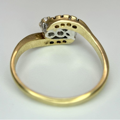 565 - A 9K YELLOW GOLD DIAMOND 3 STONE TWIST RING WITH DIAMOND ACCENT SHOULDERS. 2.5G IN WEIGHT. SIZE N. R... 