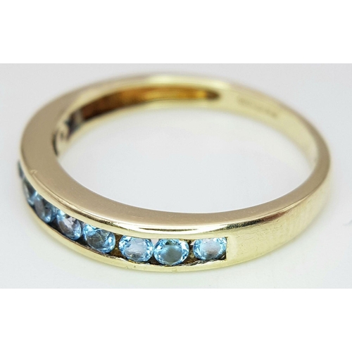 621 - A 9K YELLOW GOLD TOPAZ SET BAND RING. 1.8G IN WEIGHT. SIZE M. Ref: SC 6057