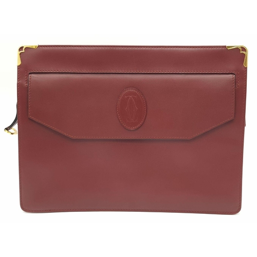 883 - A Cartier Burgundy Leather Toiletry Bag. Burgundy leather exterior with gold-toned hardware and snap... 