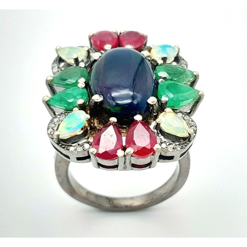 534 - A 925 silver ring featuring a central black opal, accented with emeralds, rubies, and moonstones, co... 