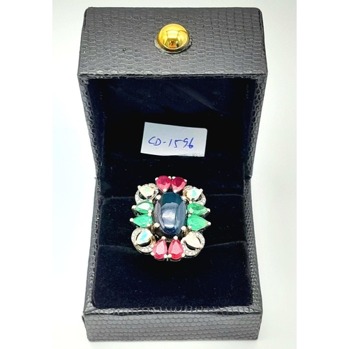 534 - A 925 silver ring featuring a central black opal, accented with emeralds, rubies, and moonstones, co... 