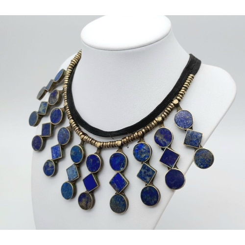 618 - A Vintage Tribal-Esque Lapis Lazuli Necklace. On white metal and textile. 47cm.