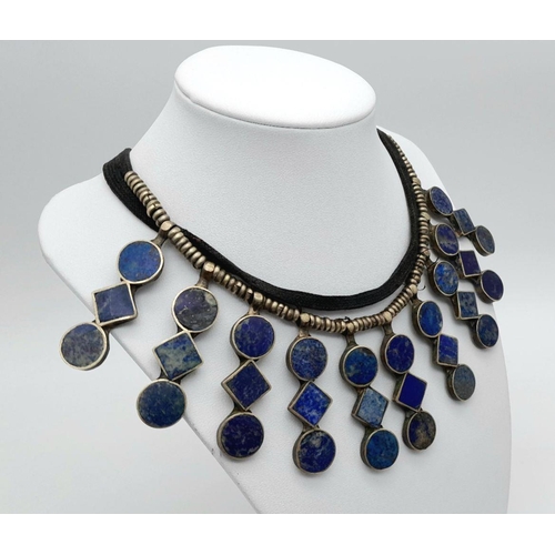 618 - A Vintage Tribal-Esque Lapis Lazuli Necklace. On white metal and textile. 47cm.