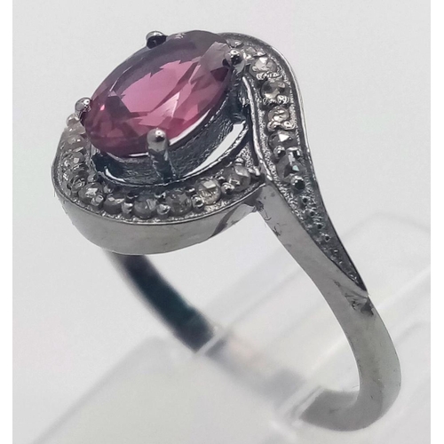 1899 - A Garnet and Diamond Ring set  in 925 Silver with a Black Rhodium coating. Oval cut Garnet- 0.80ct. ... 