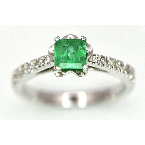 193 - AN 18K WHITE GOLD EMERALD SOLITAIRE RING - 0.44CT. WITH DIAMOND SHOULDERS. 3.1G. SIZE L. JR116