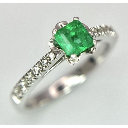 193 - AN 18K WHITE GOLD EMERALD SOLITAIRE RING - 0.44CT. WITH DIAMOND SHOULDERS. 3.1G. SIZE L. JR116