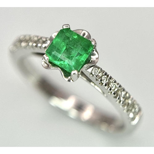 193 - AN 18K WHITE GOLD EMERALD SOLITAIRE RING - 0.44CT. WITH DIAMOND SHOULDERS. 3.1G. SIZE L. JR116