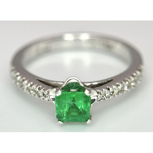 193 - AN 18K WHITE GOLD EMERALD SOLITAIRE RING - 0.44CT. WITH DIAMOND SHOULDERS. 3.1G. SIZE L. JR116