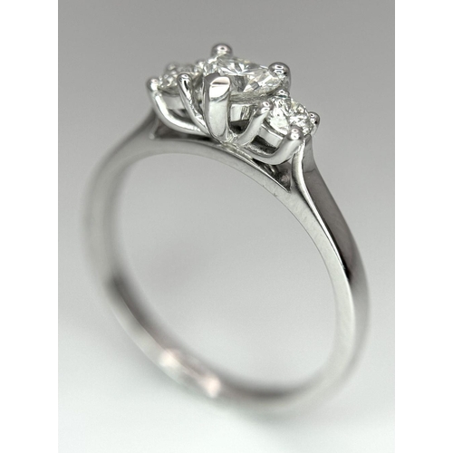 661 - An 18K White Gold and Diamond Ring. Central heart shaped diamond - 0.3ct with a 0.15ct diamond eithe... 