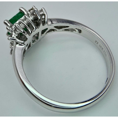 437 - AN 18K WHITE GOLD DIAMOND AND EMERALD CLUSTER RING. 0.38CTW DIAMONDS AND 0.52CT EMERALD. 4.5G. SIZE ... 