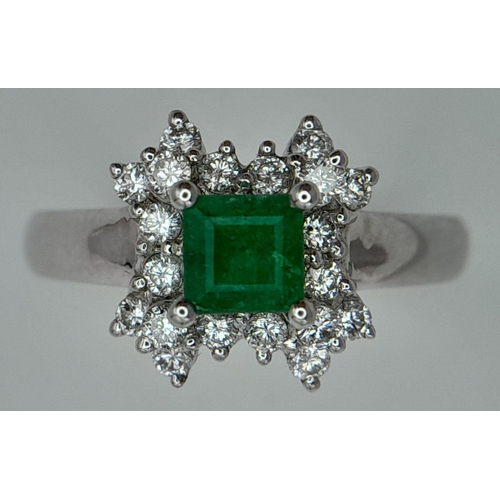 437 - AN 18K WHITE GOLD DIAMOND AND EMERALD CLUSTER RING. 0.38CTW DIAMONDS AND 0.52CT EMERALD. 4.5G. SIZE ... 