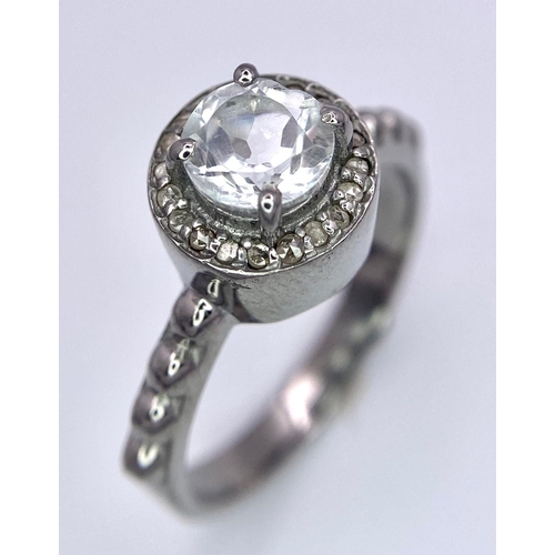 1745 - A Green Amethyst and Diamond Ring set in 925 Silver. Central round cut amethyst with a diamond halo.... 