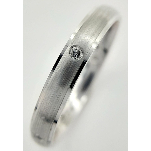 221 - AN 18K WHITE GOLD DIAMOND SET BAND RING - FROSTED CENTRE. 3.6G. SIZE O. A/S 1172