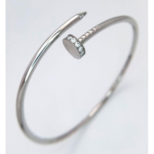 654 - An 18K White Gold Diamond Nail Design Bangle. 8.4g total weight. NL94204