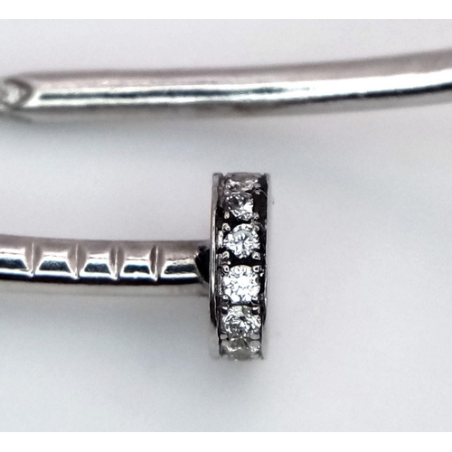 654 - An 18K White Gold Diamond Nail Design Bangle. 8.4g total weight. NL94204