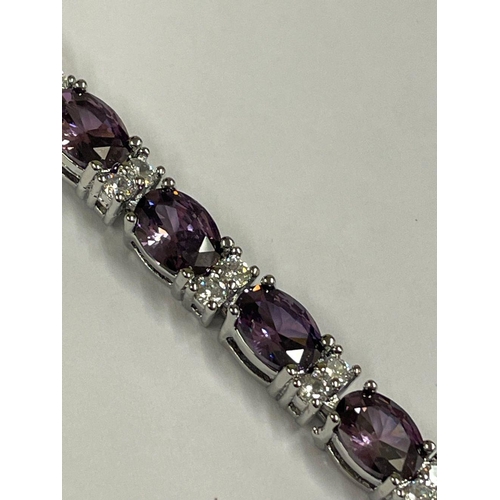 1824 - A silver tennis bracelet set with faceted amethyst stones.