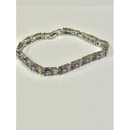 1824 - A silver tennis bracelet set with faceted amethyst stones.