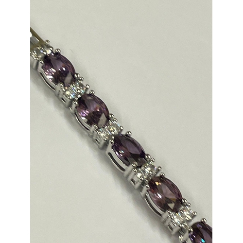 1824 - A silver tennis bracelet set with faceted amethyst stones.