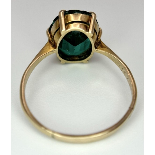 1039 - A 9K Yellow Gold Green Stone Ring. Size M. 2g