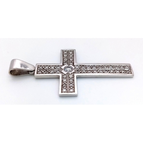 127 - A 9K White Gold Diamond Cross Pendant. 0.5ct central brilliant round cut diamond with a further 36 r... 