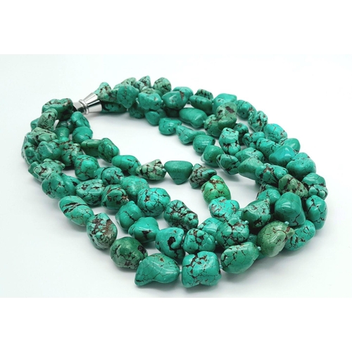 241 - A four-strand turquoise necklace of Pharaonic proportions. Large turquoise nuggets 13-23 mm, with st... 