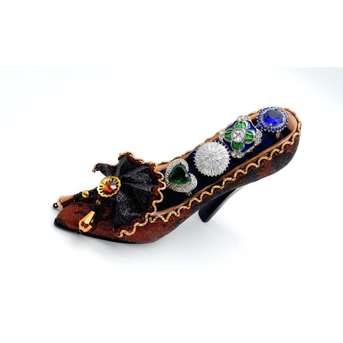 248 - Four glamorous dress rings with gems presented on an old-fashioned shoe, ring size N-O. In original ... 