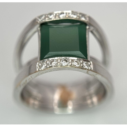 18 - A 21k White Gold, Emerald and Diamond Orbital Ring. A large 3ct square cut central emerald with diam... 