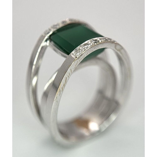 18 - A 21k White Gold, Emerald and Diamond Orbital Ring. A large 3ct square cut central emerald with diam... 