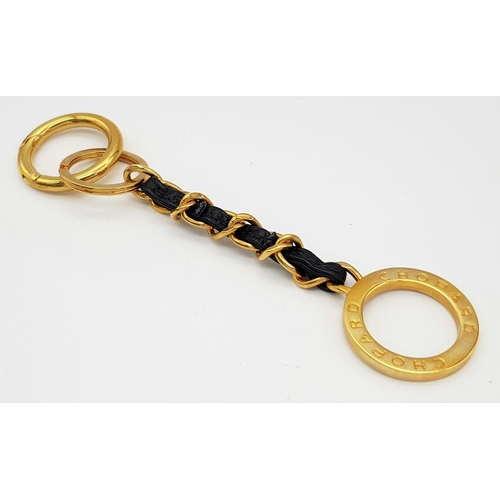 366 - A Chopard Designer Key Ring. Gilded metal and black leather. 15cm.