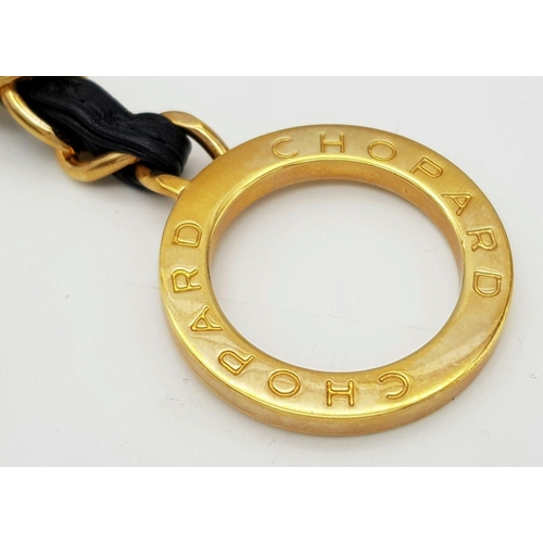 366 - A Chopard Designer Key Ring. Gilded metal and black leather. 15cm.