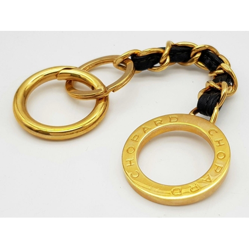 366 - A Chopard Designer Key Ring. Gilded metal and black leather. 15cm.