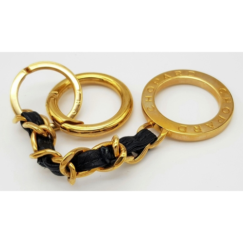 366 - A Chopard Designer Key Ring. Gilded metal and black leather. 15cm.