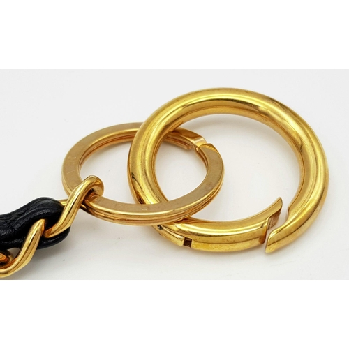 366 - A Chopard Designer Key Ring. Gilded metal and black leather. 15cm.