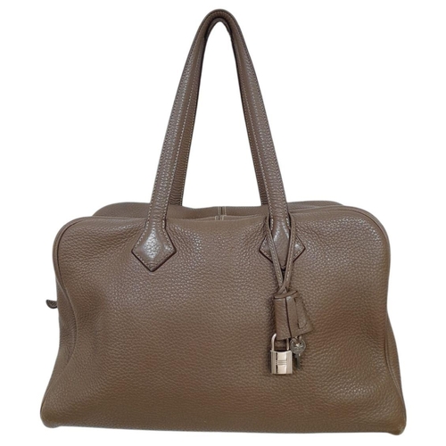 60 - A Hermes Taurillon Clemence Victoria II 35 Handbag. Etoupe leather exterior with silver toned hardwa... 