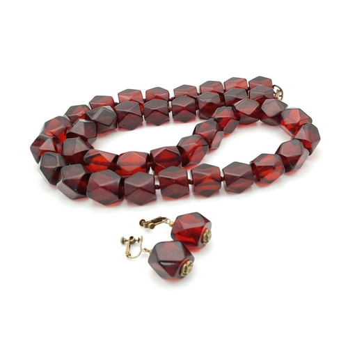 1571 - A matching set of faceted cherry-coloured resin necklace and earrings. Necklace approx 93cm in lengt... 