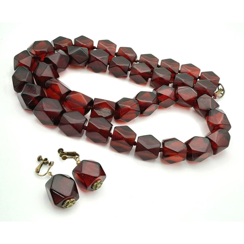 1571 - A matching set of faceted cherry-coloured resin necklace and earrings. Necklace approx 93cm in lengt... 