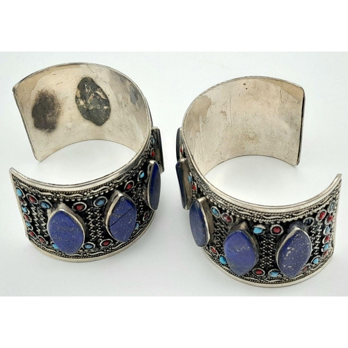 1592 - A Pair of Lapis Lazuli White Metal Cuff Bangles. Approx 6.7cm diameter, 129g total weight.