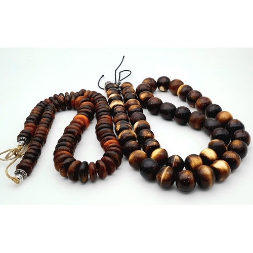 1768 - A pair of African tribal resin necklaces, featuring one with large graduated round beads (apprsox 11... 