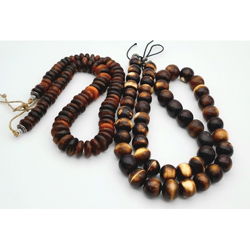 1768 - A pair of African tribal resin necklaces, featuring one with large graduated round beads (apprsox 11... 