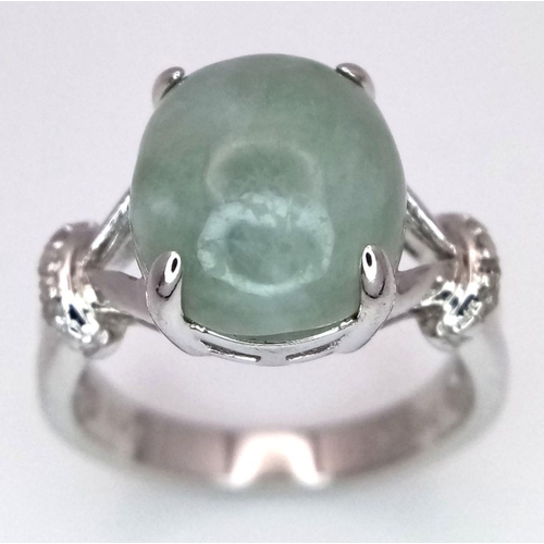 1875 - A Sterling Silver Prehnite Cabochon and Diamond Set Ring Size N. The Ring is set with a 1.2cm Oval C... 