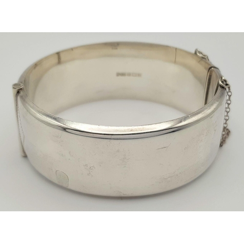 247 - A Vintage Solid Silver 925 Bangle, 42.5 grams, Approx. 6cm diameter, with safety chain. In very good... 