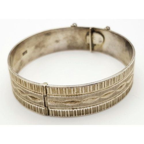 423 - A Vintage Solid Silver 925 Bangle, 40.5 grams, Approx. 6cm diameter, with safety chain. In very good... 