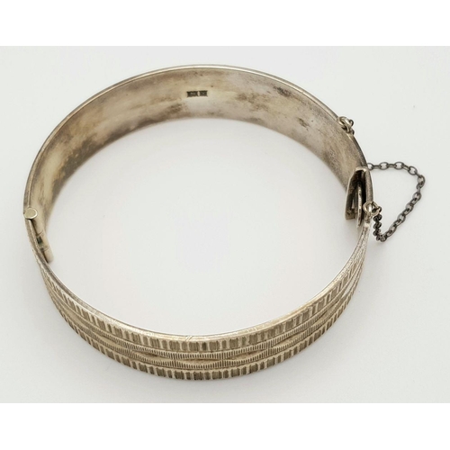 423 - A Vintage Solid Silver 925 Bangle, 40.5 grams, Approx. 6cm diameter, with safety chain. In very good... 